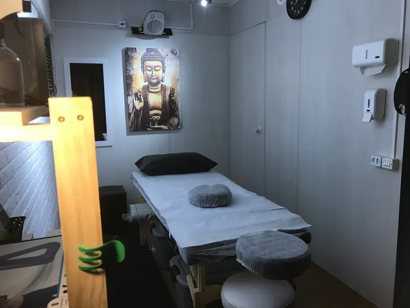 Sala de massagem terapêutica da Zang Fu Consolação com maca e quadro de Buda