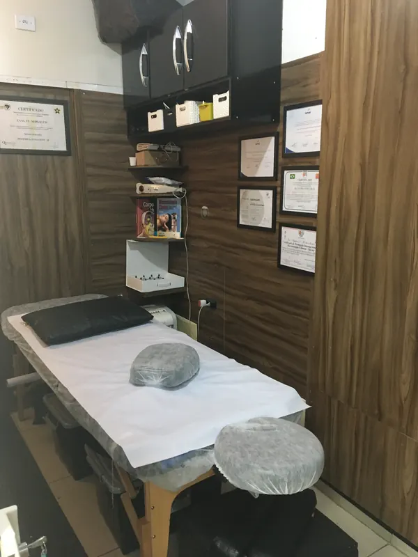 Sala de massoterapia da Zang Fu Pinheiros com maca e parede de madeira