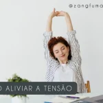 Mulher sentada à mesa de trabalho espreguiçando os braços acima da cabeça para aliviar a tensão
