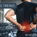Homem em academia com as mãos na lombar destacada em vermelho, com dor muscular pós-treino